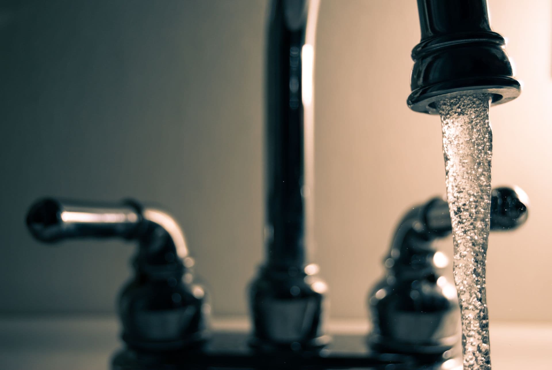 Plumber working on a leak under a kitchen sink