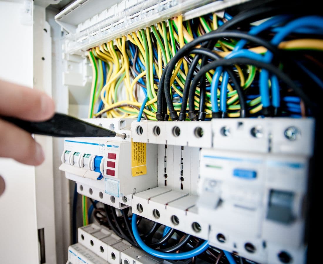 Electrician working on an opened consumer unit / switchboard