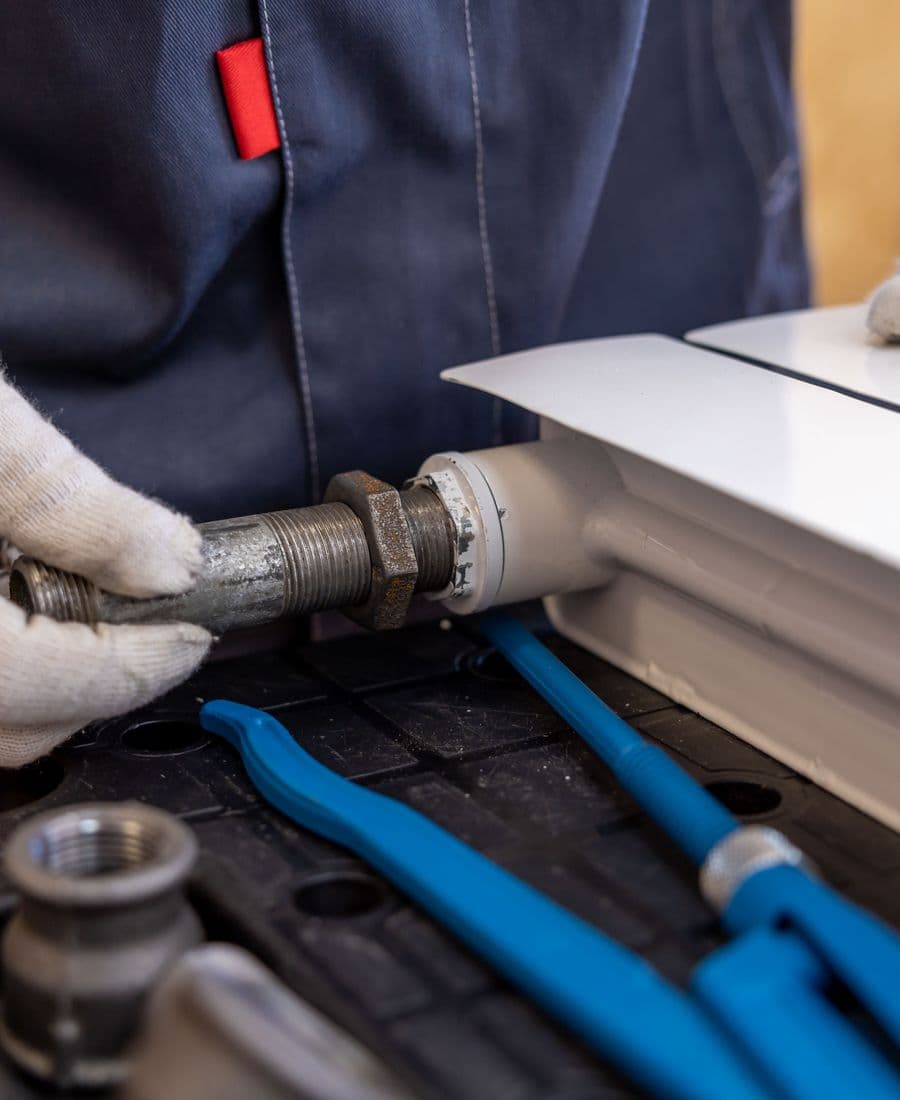 Plumber installing radiator pipework during a power flush