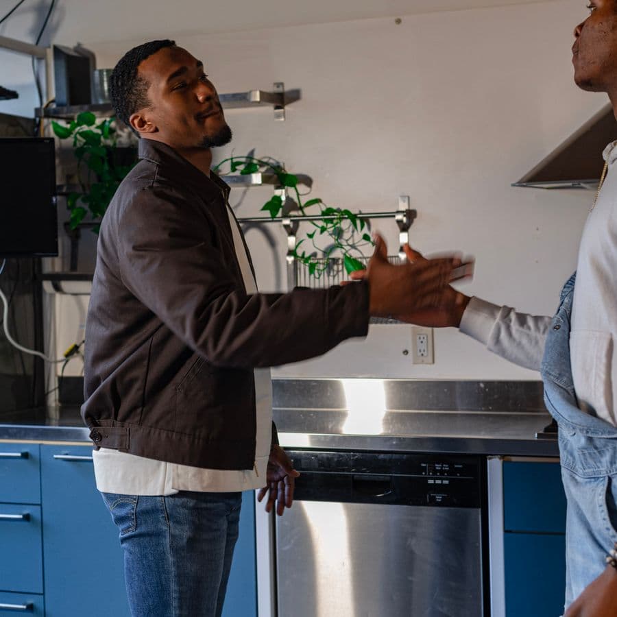 Tradesman and homeowner shaking hands in a modern kitchen after the job